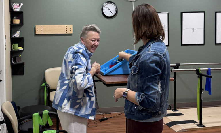 Older woman working with a physical therapist during a therapy session.